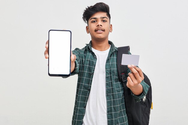 Estudante universitário indiano mostrando a tela do celular e cartão em fundo branco