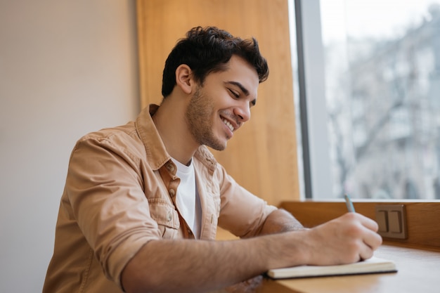 Estudante universitário sorridente estudando