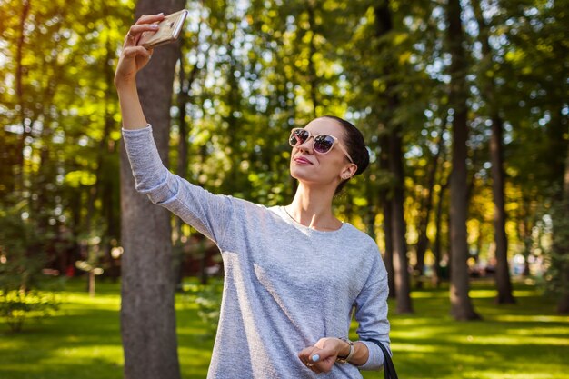 Estudante universitário tirando selfie no celular no parque