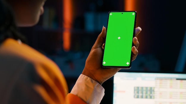 Estudante usa tela verde no layout do telefone enquanto examina o software do plano de caixa