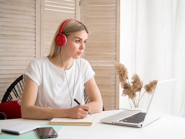 Foto estudante usando fones de ouvido vermelhos cursos on-line