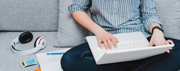 Estudante usando laptop no sofá