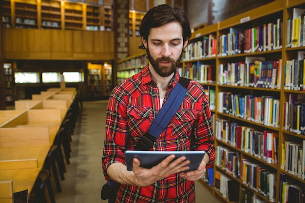 Estudante usando seu tablet na biblioteca