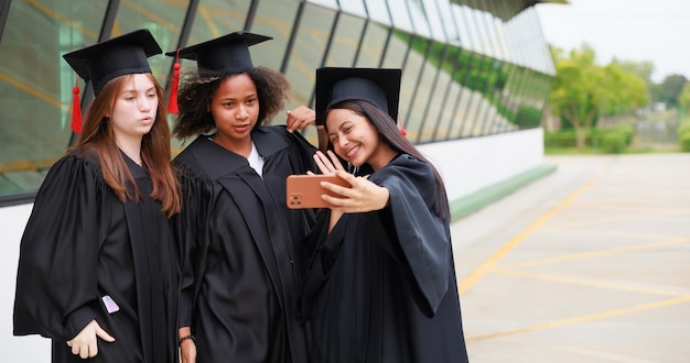 Estudante vestindo vestido e fazendo foto por smartphone se formando Feliz pós-graduação sucesso e celebração Parabéns