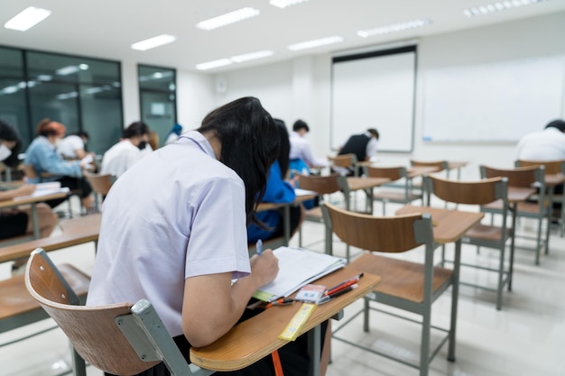 Foto estudantes adolescentes tomando notas enquanto ouvem a palestra na sala de aula