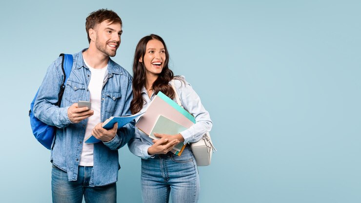 Foto estudantes alegres com livros e espaço livre para smartphones