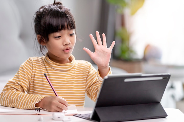 Estudantes asiáticas em aulas de aprendizagem online estudam online com tablet em casa