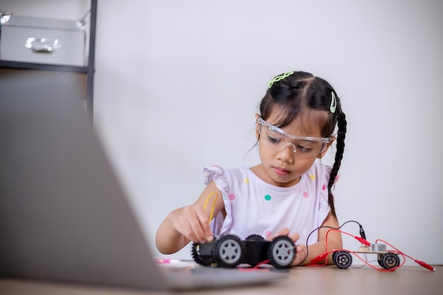 Estudantes asiáticos aprendem em casa codificando carros robôs e cabos de placas eletrônicas em STEM STEAM matemática engenharia ciência tecnologia código de computador em robótica para conceitos infantis