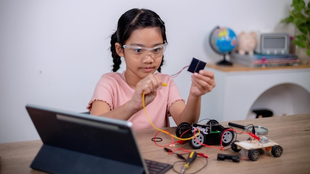Estudantes asiáticos aprendem em casa codificando carros robôs e cabos de placas eletrônicas em stem steam matemática engenharia ciência tecnologia código de computador em robótica para conceitos infantis