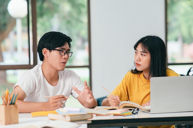 Estudantes asiáticos estão lendo livros e estudando tutoria juntos