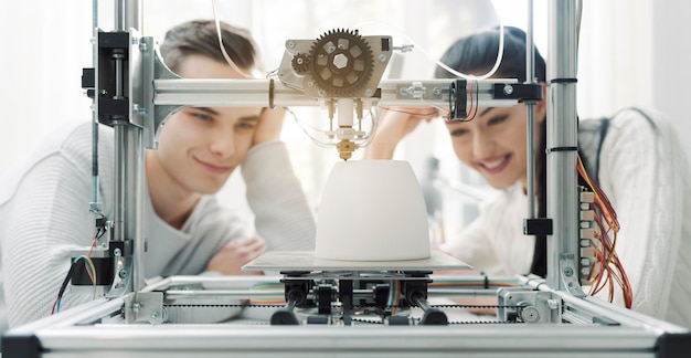 Estudantes de engenharia usando uma impressora 3D no laboratório