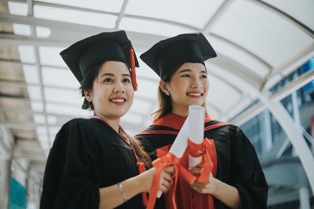 estudantes de graduação segurando diplomas e moedas de ouro