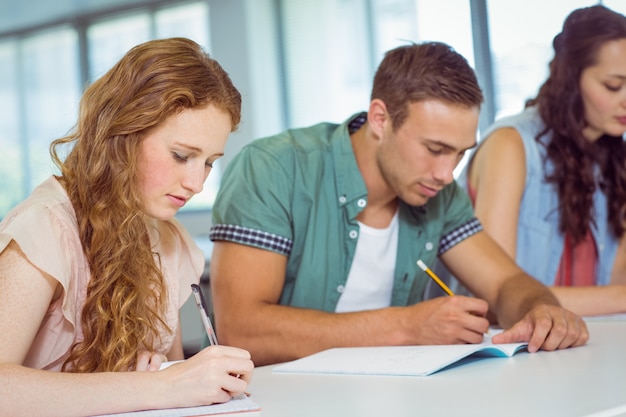 Estudantes de moda que tomam notas na aula