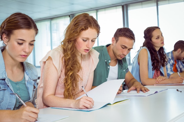 Estudantes de moda tomando notas em sala de aula