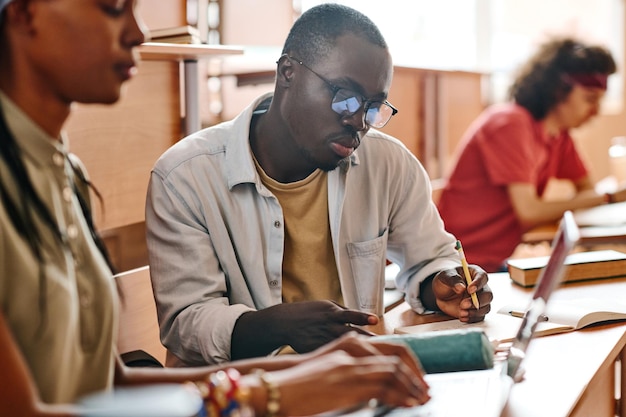 Estudantes escrevendo exame na mesa da universidade