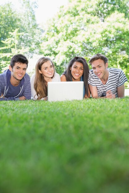 Estudantes felizes usando laptop fora