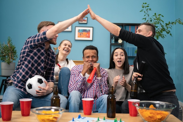 Foto estudantes multiétnicos alegres e felizes torcendo pelo time favorito e marcando gol e vencendo o jogo