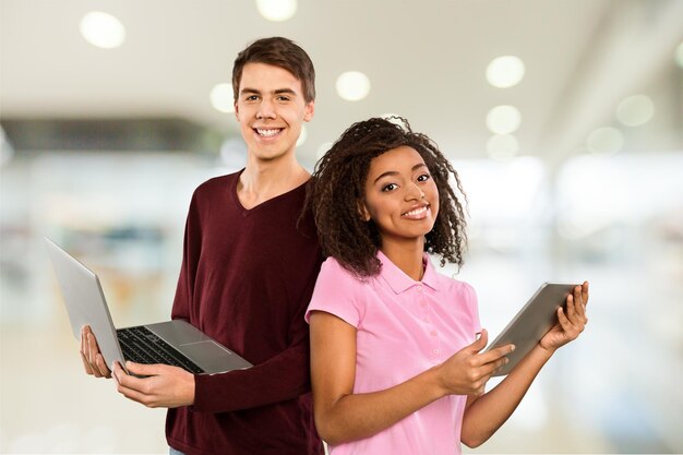 Estudantes multiétnicos com tablet e laptop