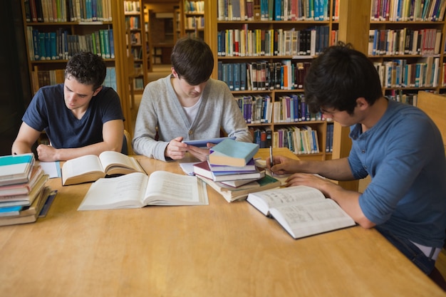 Foto estudantes que realizam tarefas na biblioteca