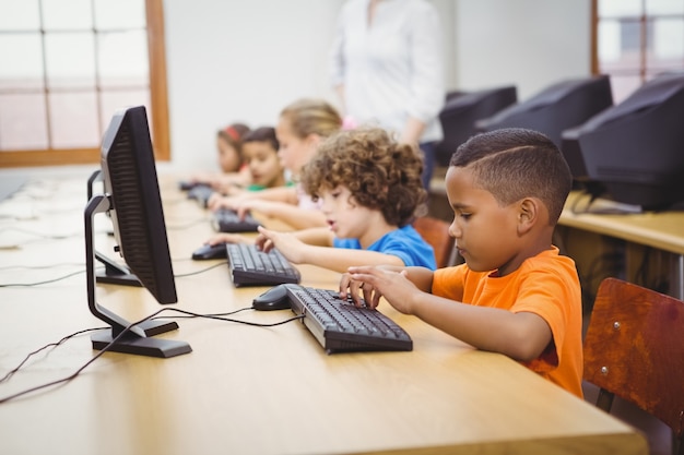 Foto estudantes que usam computadores na sala de aula