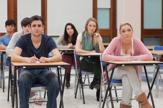 Estudantes sentados na sala de aula ouvindo