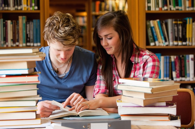 Estudantes sérios que olham para um livro