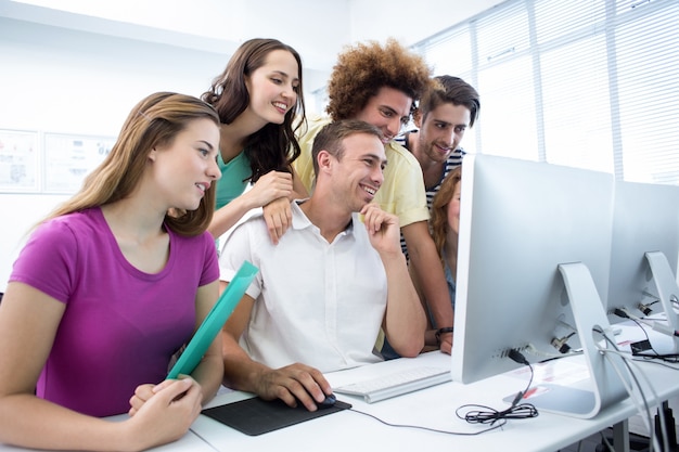 Foto estudantes sorridentes na aula de informática