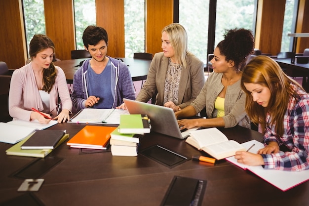 Estudantes sorridentes trabalhando juntos em uma tarefa