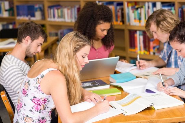 Estudantes universitários fazendo lição de casa na biblioteca