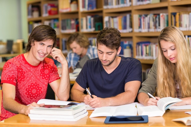 Estudantes universitários fazendo lição de casa na biblioteca