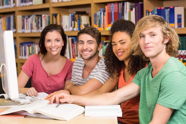 Estudantes universitários usando computador na biblioteca