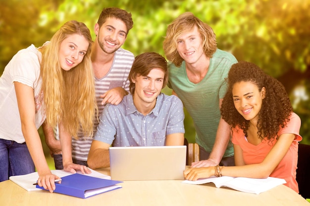 Estudantes universitários usando laptop na biblioteca contra árvores e prados no parque