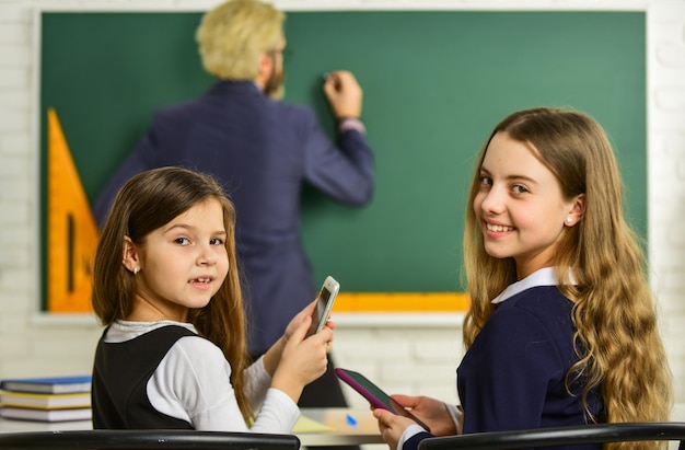 Estudar muito divulgar e desenvolver a criatividade Professor trabalhando com Creative Kids meninas crianças na escola de volta à escola Professor e aluno trabalhando juntos na mesa na escola primária