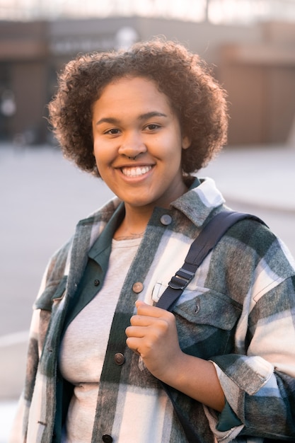 Estudiante adolescente alegre con mochila pasar tiempo al aire libre