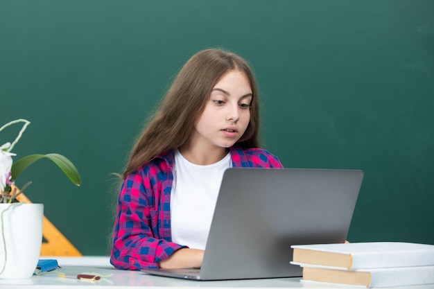 Estudiante adolescente con una computadora portátil en la escuela estudiante adolescente trabajando en una computadora portable en el aula