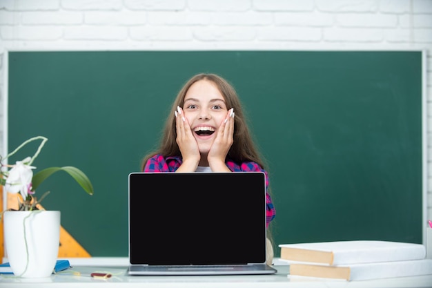 Estudiante adolescente con una computadora portátil en la escuela estudiante adolescente trabajando en una computadora portable en el aula
