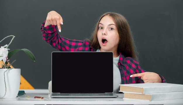Estudiante adolescente con una computadora portátil en la escuela estudiante adolescente trabajando en una computadora portable en el aula