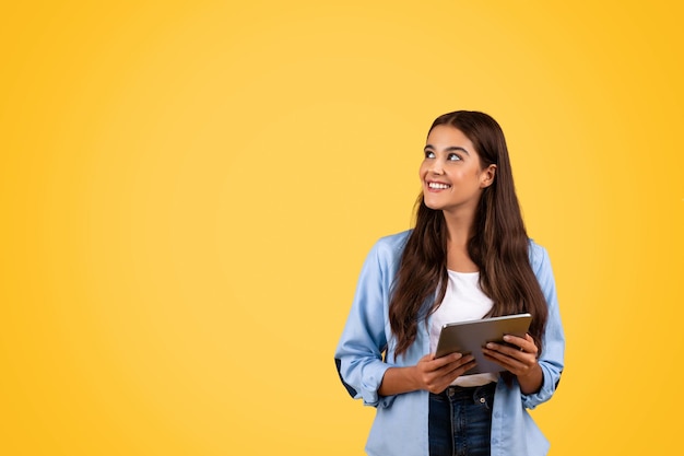 Foto estudiante adolescente que usa tabletas que combinan estudio y tecnología en un estilo de vida de temática amarilla