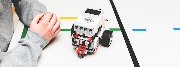Foto estudiante adolescente con robot diy en clase de educación de tallo científico adolescente trabajando en un nuevo proyecto de educación de tallo aprendiendo a programar vehículo robótico banner