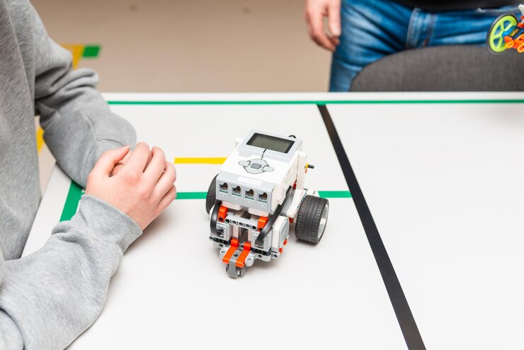Foto estudiante adolescente con robot diy en clase de educación de tallo científico adolescente trabajando en un nuevo proyecto de educación de tallo aprendiendo a programar vehículo robótico