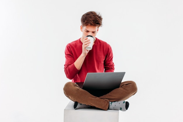 Estudiante adolescente con taza de café para ir a trabajar en la computadora portátil