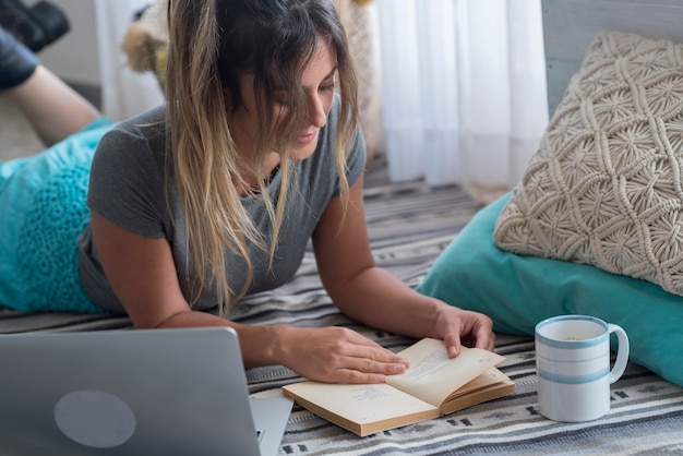 Foto estudiante adulto joven en casa con portátil y libro