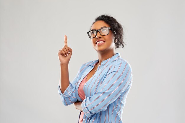 estudiante africana con gafas señala el dedo hacia arriba