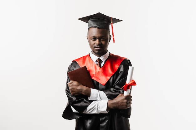 Estudiante africano confiado con diploma en bata de graduación y gorra lista para terminar la universidad Futuro líder de la ciencia Académico hombre africano en vestido negro sonriendo