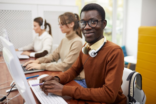 Estudiante afroamericano usando la computadora en la universidad