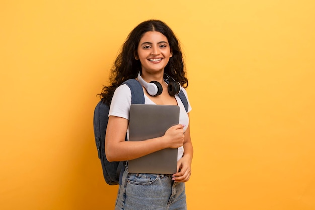 Foto estudiante alegre con auriculares y portátil