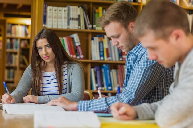 Estudiante con amigos en el mostrador de la biblioteca