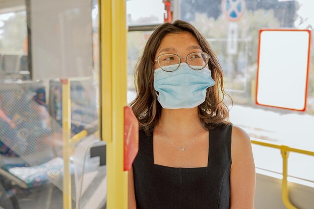 Estudiante de ascendencia asiática viaja en autobús de transporte público para asistir a clases en la universidad