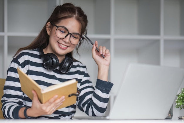 Foto estudiante asiática estudiando en línea en clase estudiando en línea con auriculares viendo videollamadas haciendo zoom feliz mujer asiática aprendiendo idiomas en línea con computadora portátil