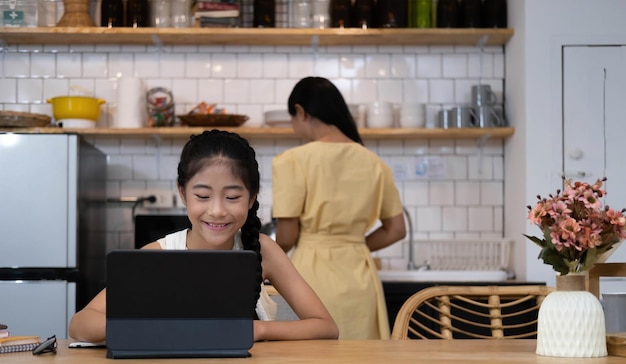 Estudiante asiática en línea, clase de aprendizaje, estudio en línea, videollamada, profesor de zoom, niña feliz, aprende inglés en línea con una computadora portátil en casa, nueva normalidad, coronavirus Covid19, distanciamiento social, quedarse en casa